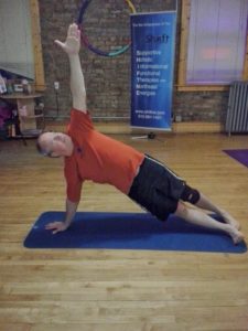 Older man holding yoga pose on yoga mat