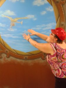 Tammy posing in front of surreal image of old flying device
