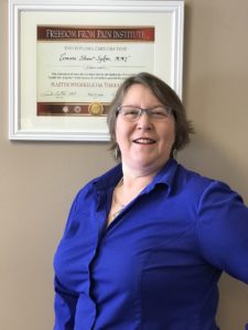 Tammy portrait shot in front of framed diploma