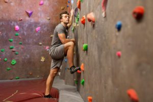 young man exercising at indoor climbing gym