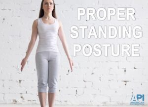 Woman standing in yoga pose against white brick background - "proper standing posture" text